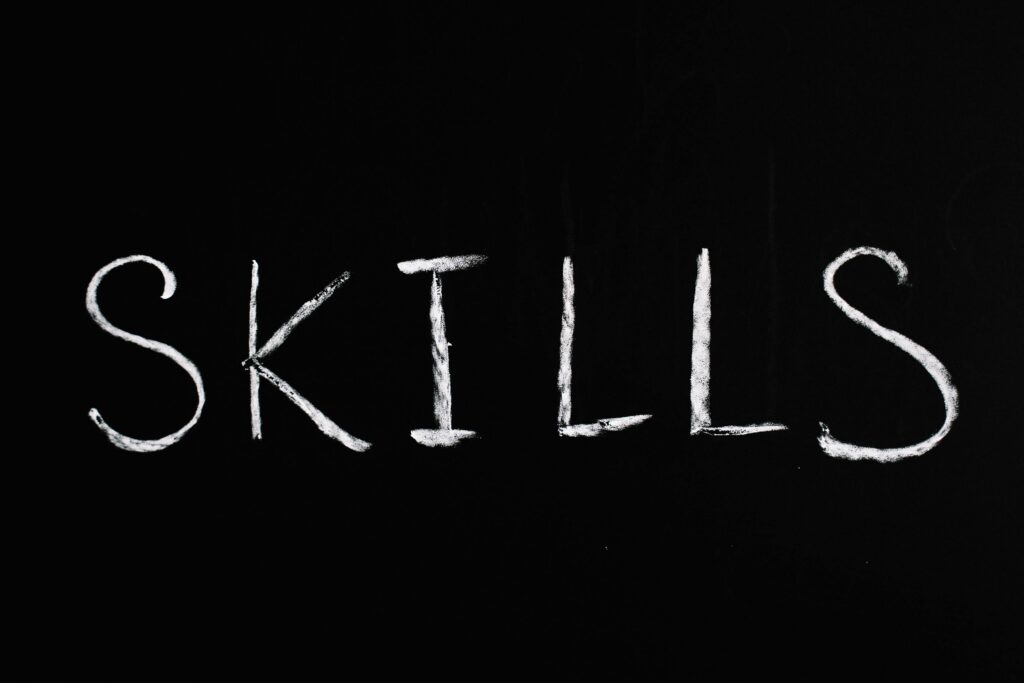 Chalk lettering of the word 'skills' on a blackboard, emphasizing learning and education.